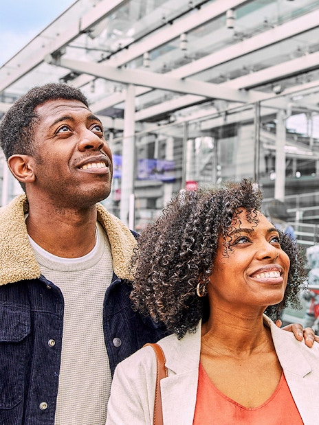 Couple smiling near Fast Track entrance to the London Eye.