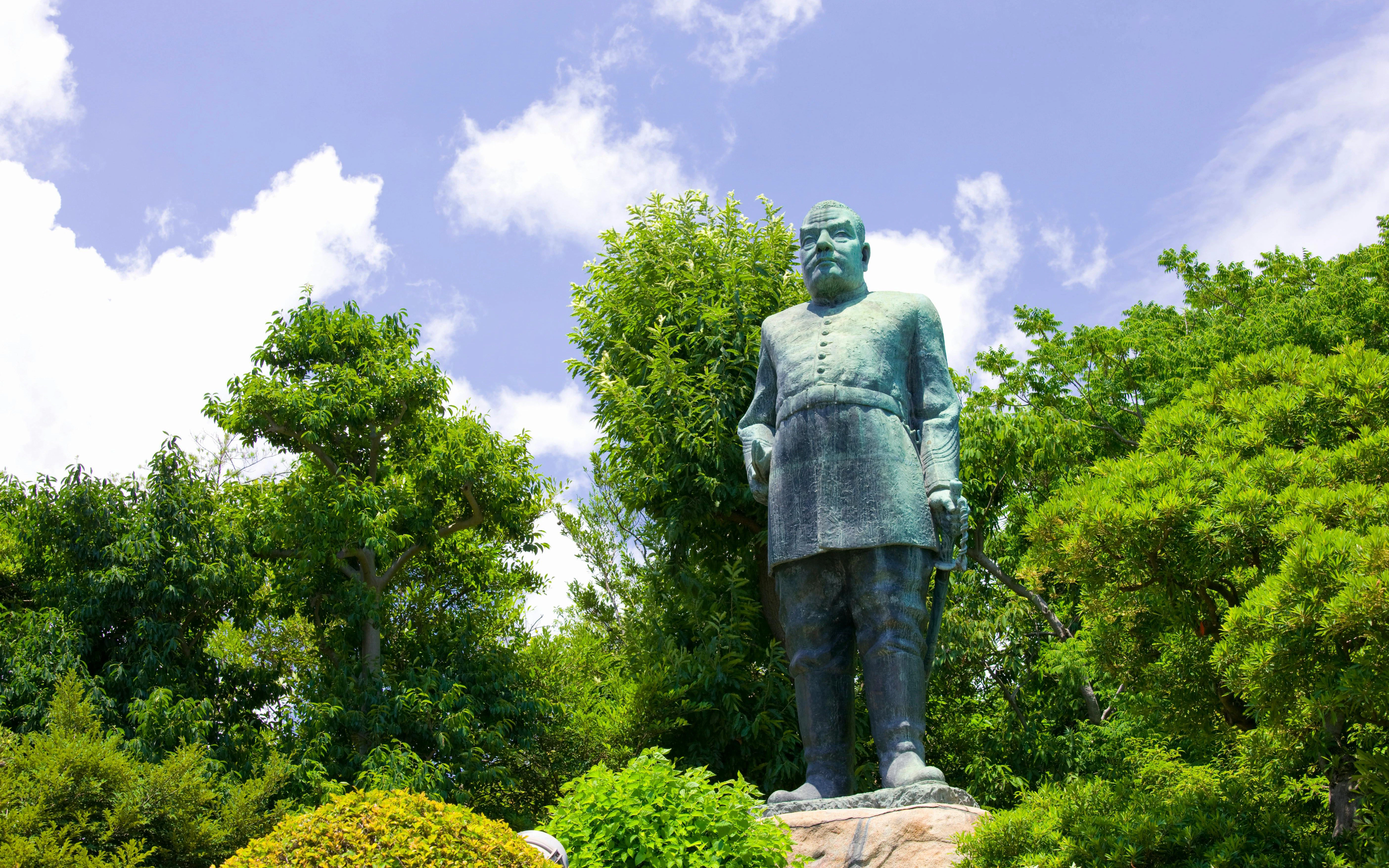 Statue of Saigo Takamori surrounded by lush greenery in Tokyo, Japan.