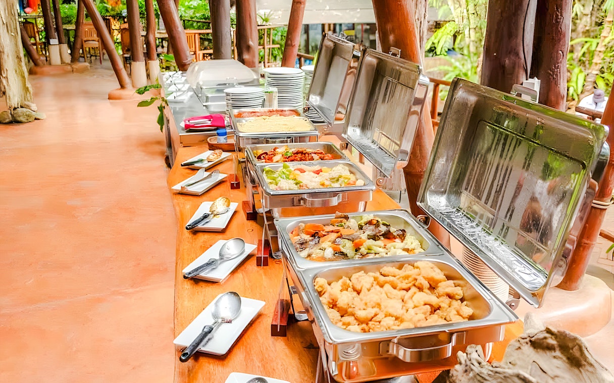 Buffet spread at Hanuman World with various dishes and cutlery.