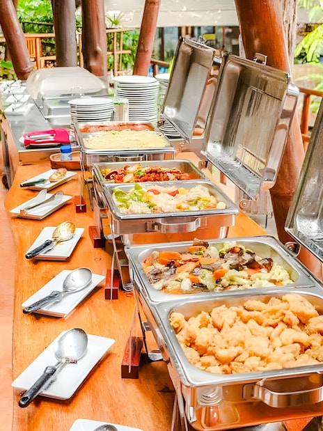 Buffet spread at Hanuman World with various dishes and cutlery.