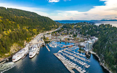 Aerial view of Horseshoe Bay marina and village surrounded by mountains and ocean during Vancouver Panorama Scenic Seaplane Tour.