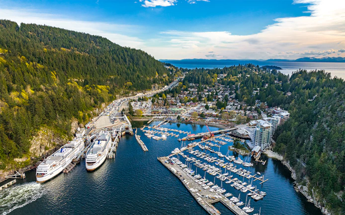 Aerial view of Horseshoe Bay marina and village surrounded by mountains and ocean during Vancouver Panorama Scenic Seaplane Tour.