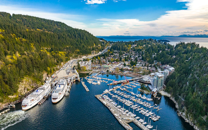Aerial view of Horseshoe Bay marina and village surrounded by mountains and ocean during Vancouver Panorama Scenic Seaplane Tour.