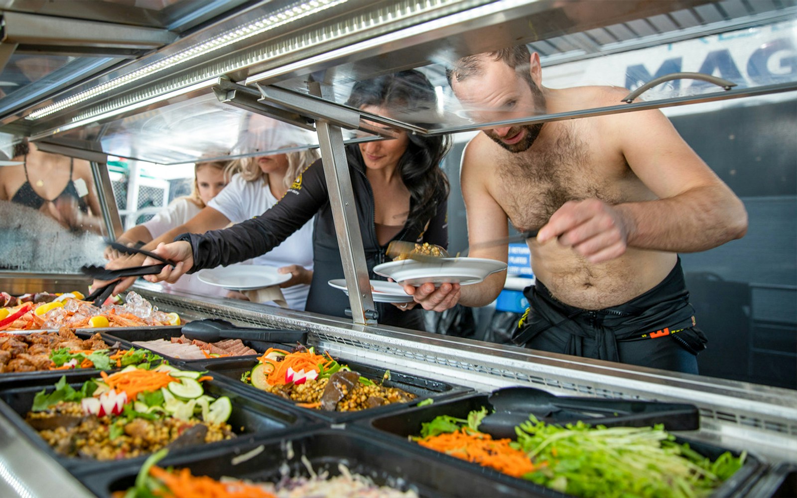 Guests enjoying buffet lunch on Cairns to Great Barrier Reef cruise.
