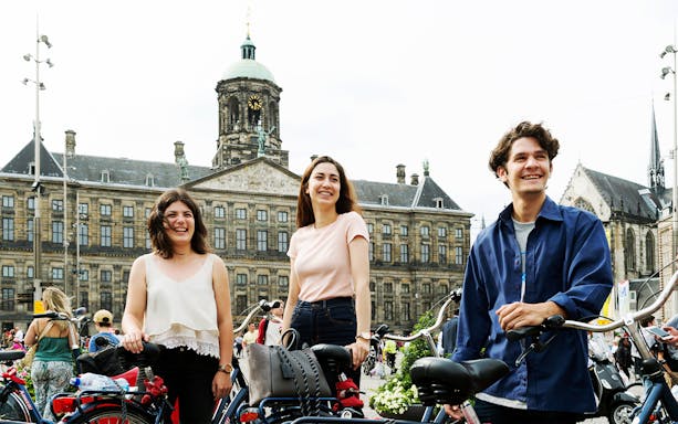 Cyclists riding along a canal in Amsterdam during a highlights tour by bike.
