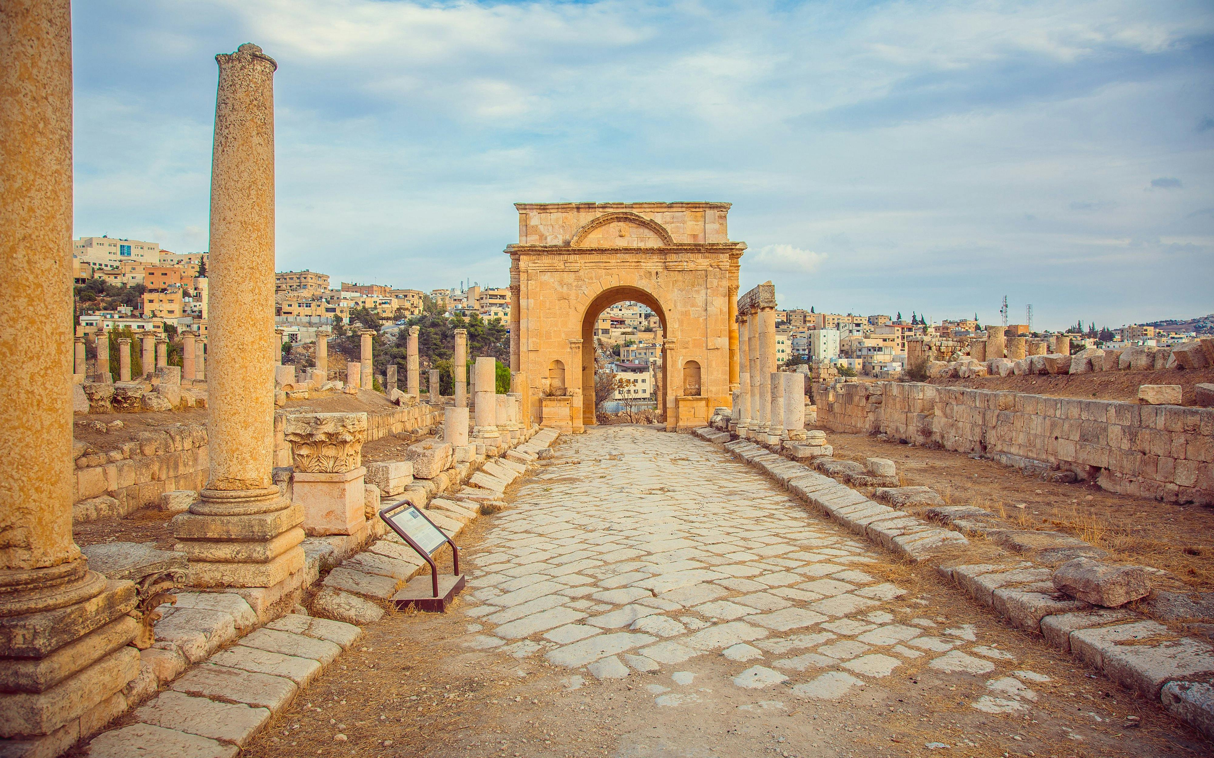 North Gate of ancient Roman city Jerash, Jordan with stone columns and archway.