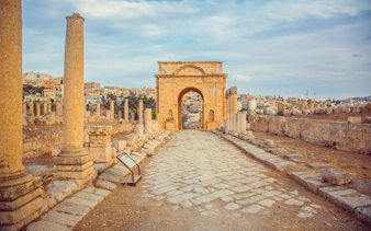 North Gate of ancient Roman city Jerash, Jordan with stone columns and archway.