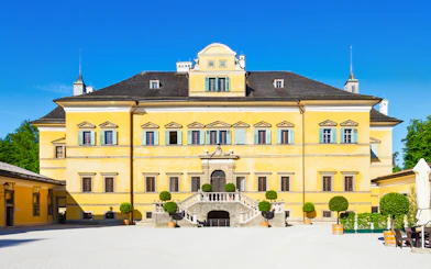 Yellow facade of Schloss Hellbrunn, a stop on the Original Sound of Music Tour from Salzburg.