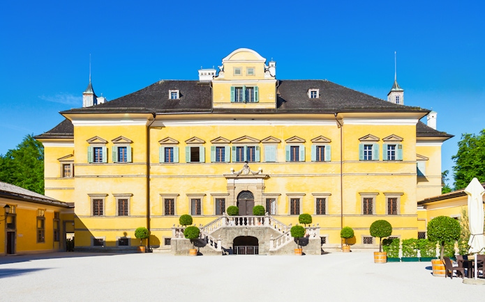 Yellow facade of Schloss Hellbrunn, a stop on the Original Sound of Music Tour from Salzburg.