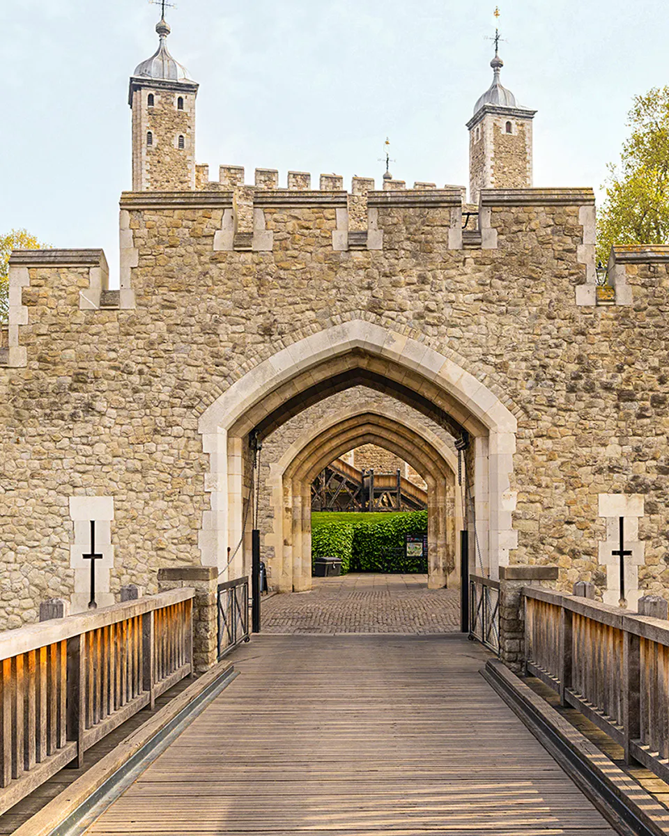 Tower of London stone entrance with arched gateway and towers.