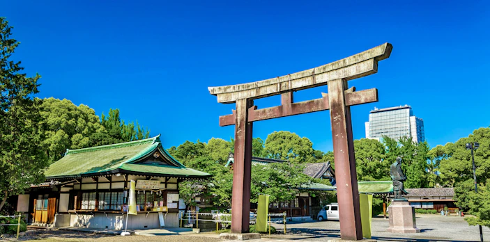 Torii gate at Hokoku Shrine with Osaka Castle in the background, Osaka, Japan.