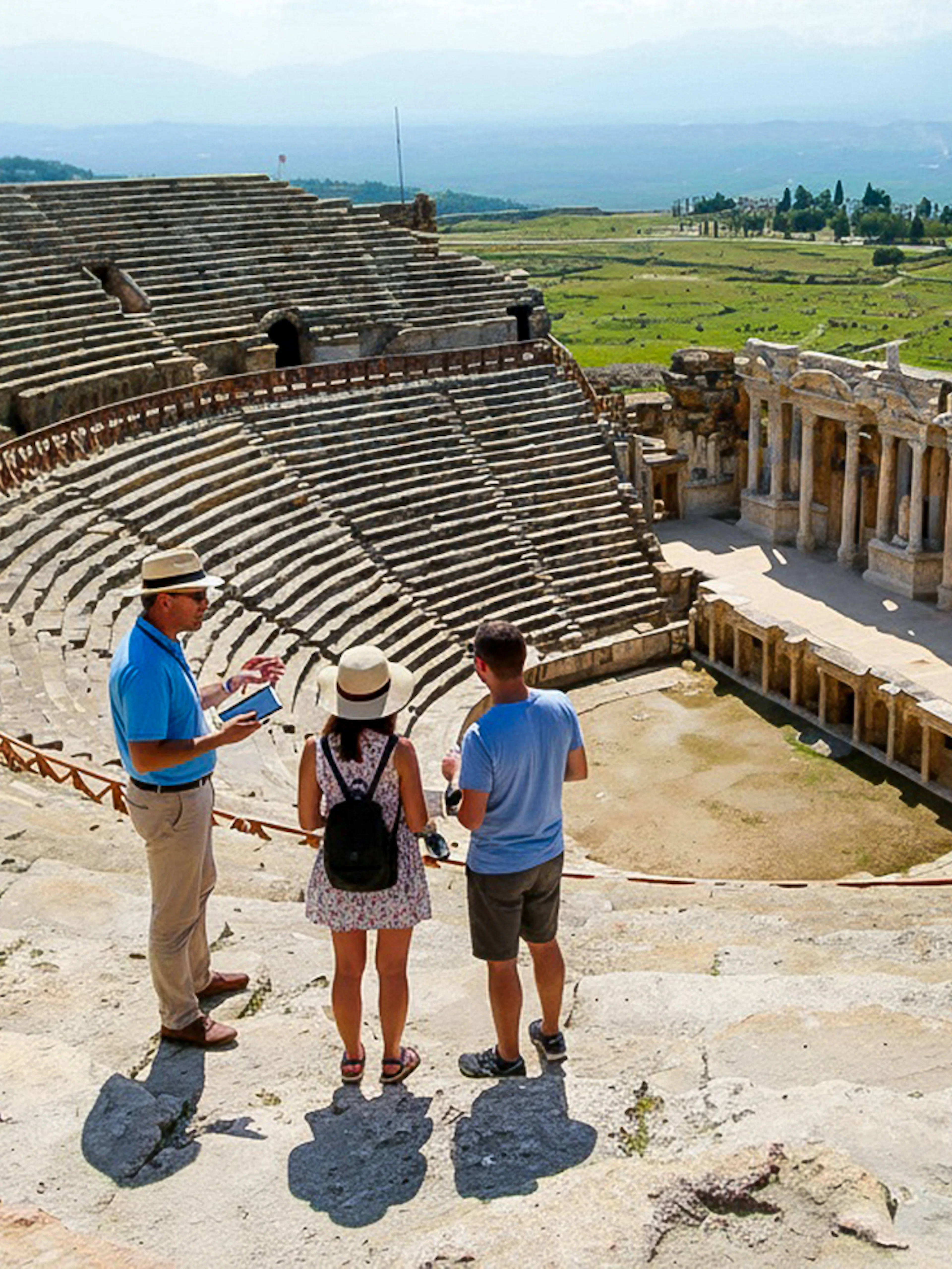 Guide explaining to tourists at the ancient theater near Apollo Temple, Turkey.