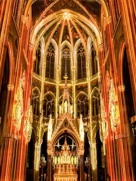 Gothic cathedral interior with illuminated arches and altar, Sainte-Chapelle, Paris.