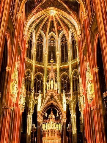 Gothic cathedral interior with illuminated arches and altar, Sainte-Chapelle, Paris.