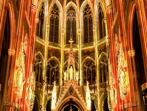 Gothic cathedral interior with illuminated arches and altar, Sainte-Chapelle, Paris.