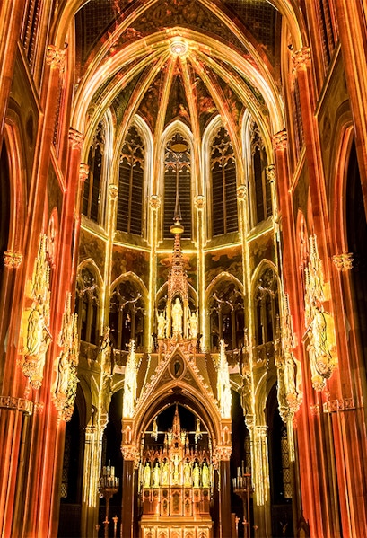 Gothic cathedral interior with illuminated arches and altar, Sainte-Chapelle, Paris.