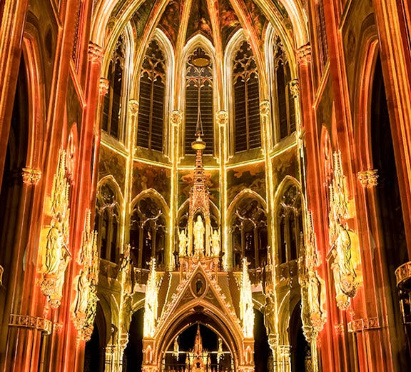 Gothic cathedral interior with illuminated arches and altar, Sainte-Chapelle, Paris.