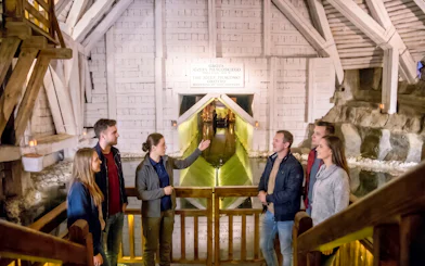 Tour group with guide inside Wieliczka Salt Mine, Krakow, near underground lake.