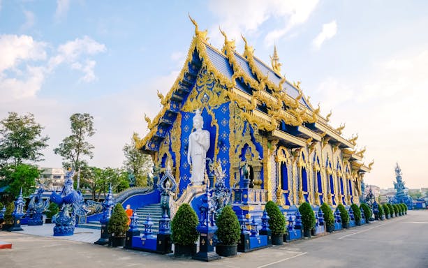Rong Suea Ten Temple with intricate blue and gold architecture, Chiang Rai, Thailand.