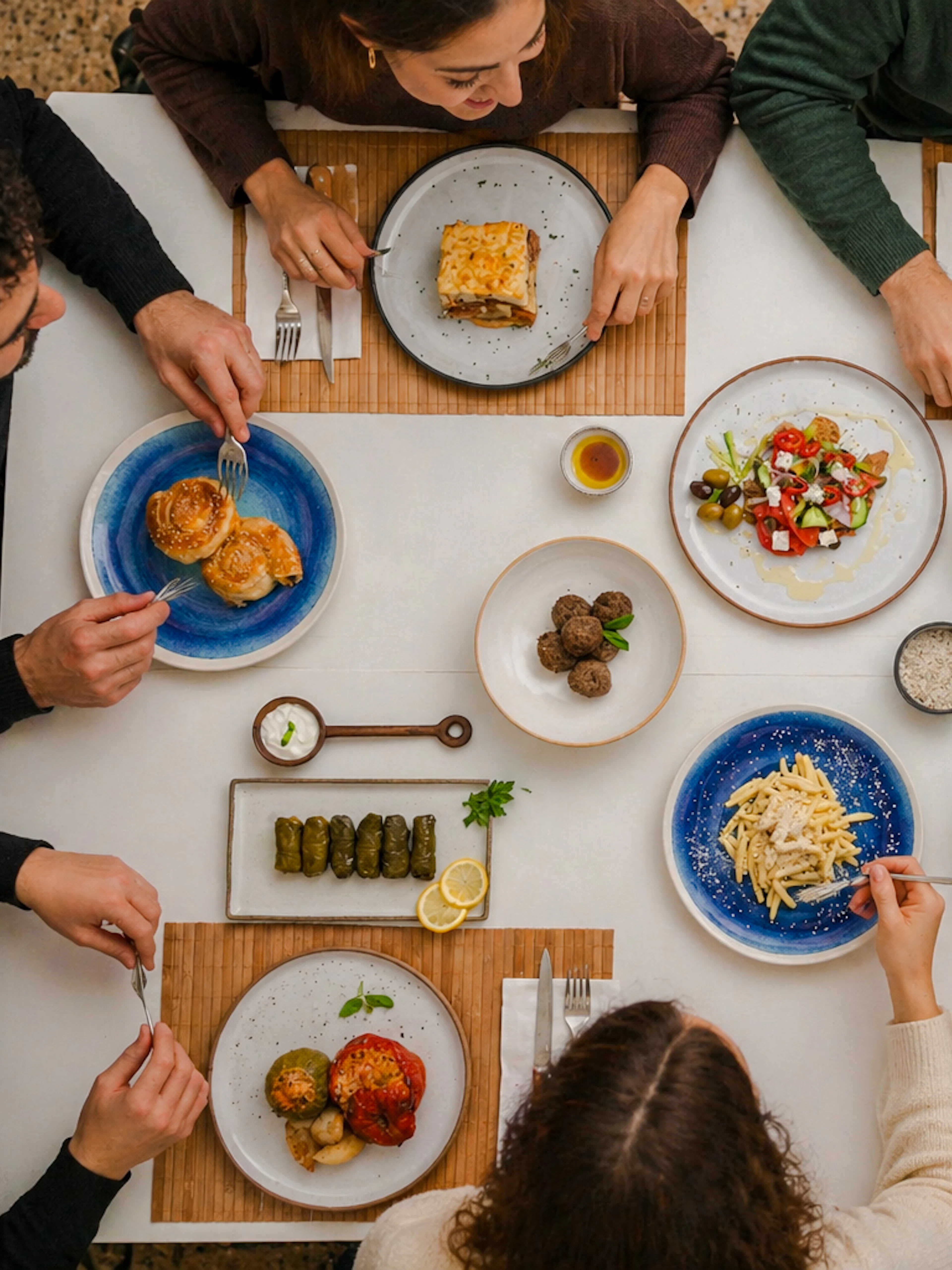 Greek cooking class in Athens with participants enjoying traditional dishes and wine.