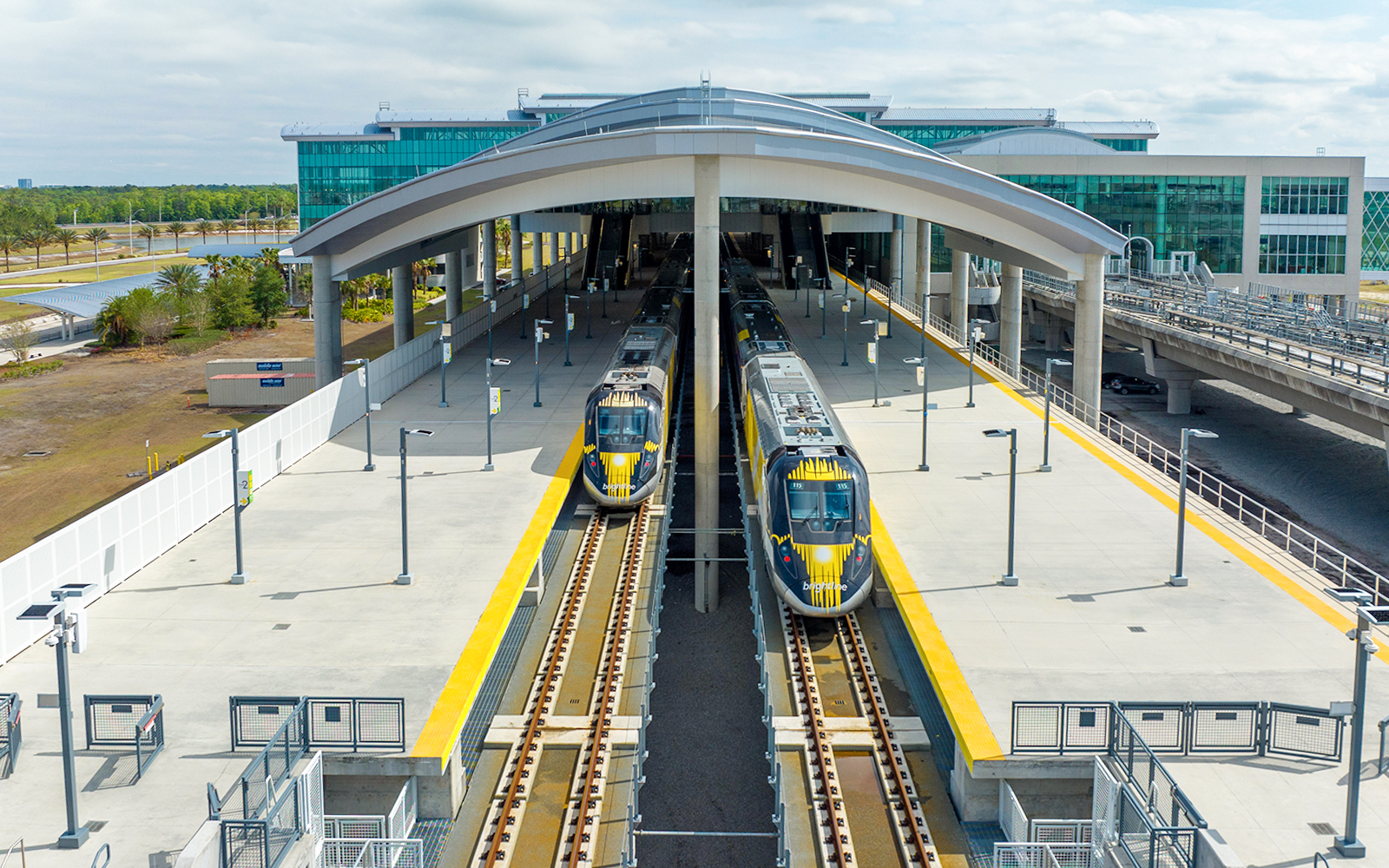 Brightline train departing modern station platform in Florida.