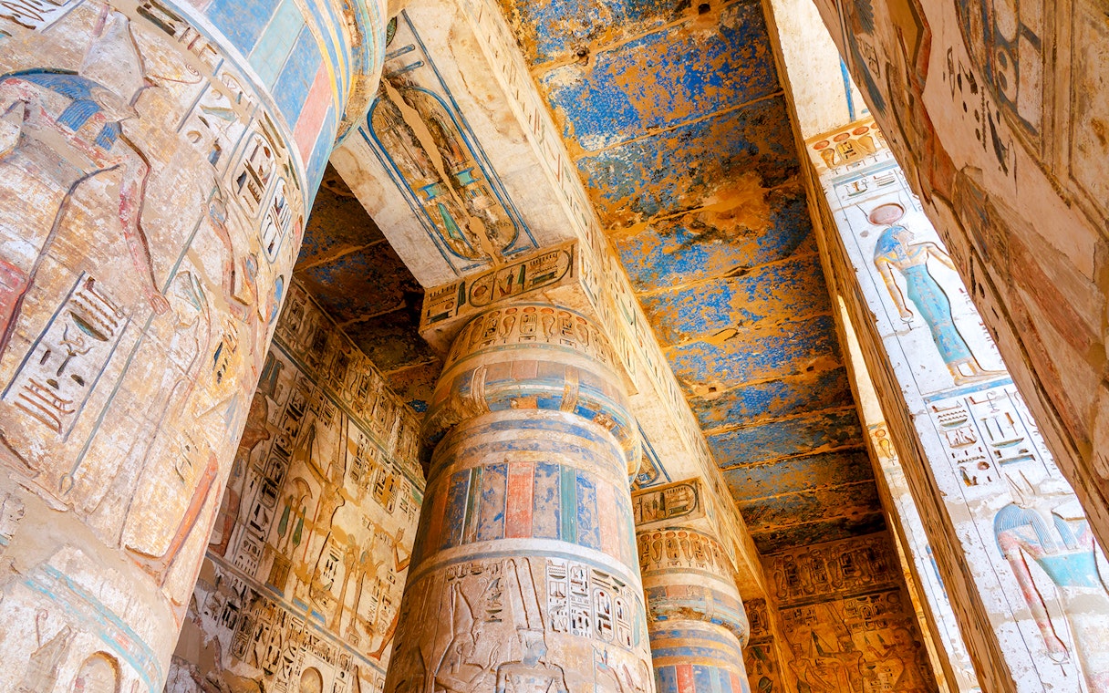 Colorful hieroglyphs on columns inside Medinet Habu temple, Luxor, Egypt.