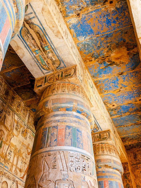 Colorful hieroglyphs on columns inside Medinet Habu temple, Luxor, Egypt.