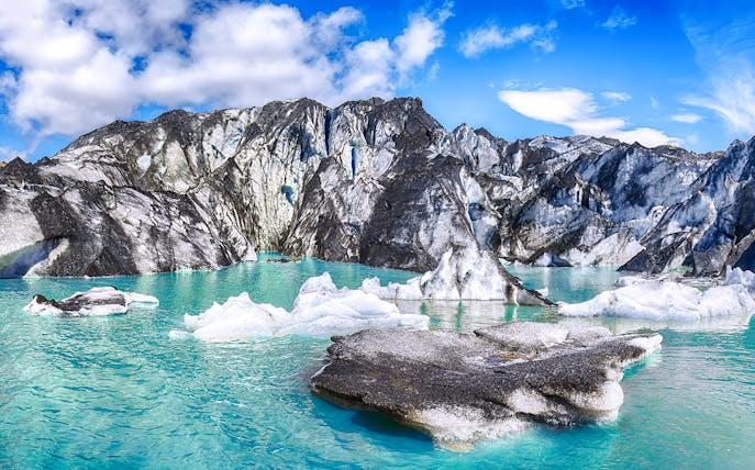 Solheimajokull glacier with turquoise meltwater and ice formations in Iceland.