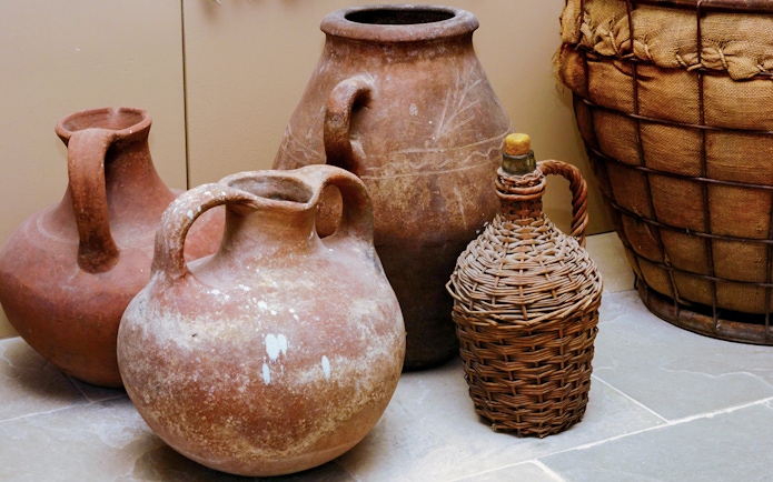 Greek antique ceramic clay pots and jugs displayed on a stone floor.