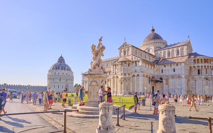 Pisa Cathedral and Baptistery with tourists exploring the square.