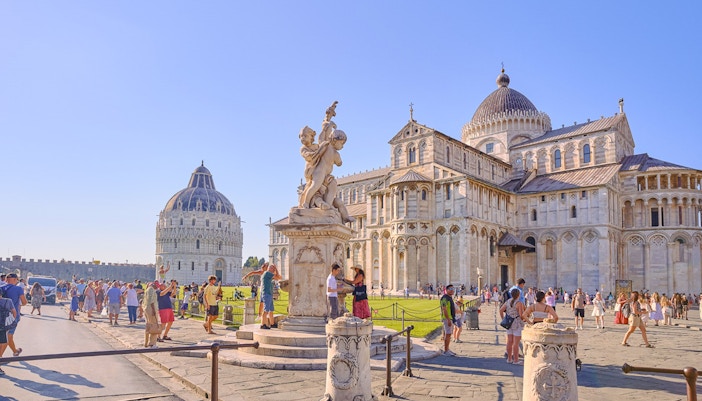 Pisa Cathedral and Baptistery with tourists exploring the square.