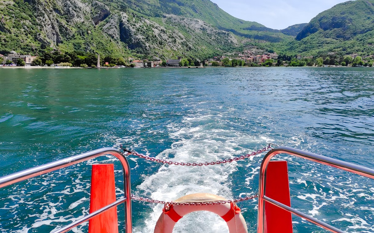 View from semi-submarine of Boka Bay, Kotor, with mountains and shoreline in the background.