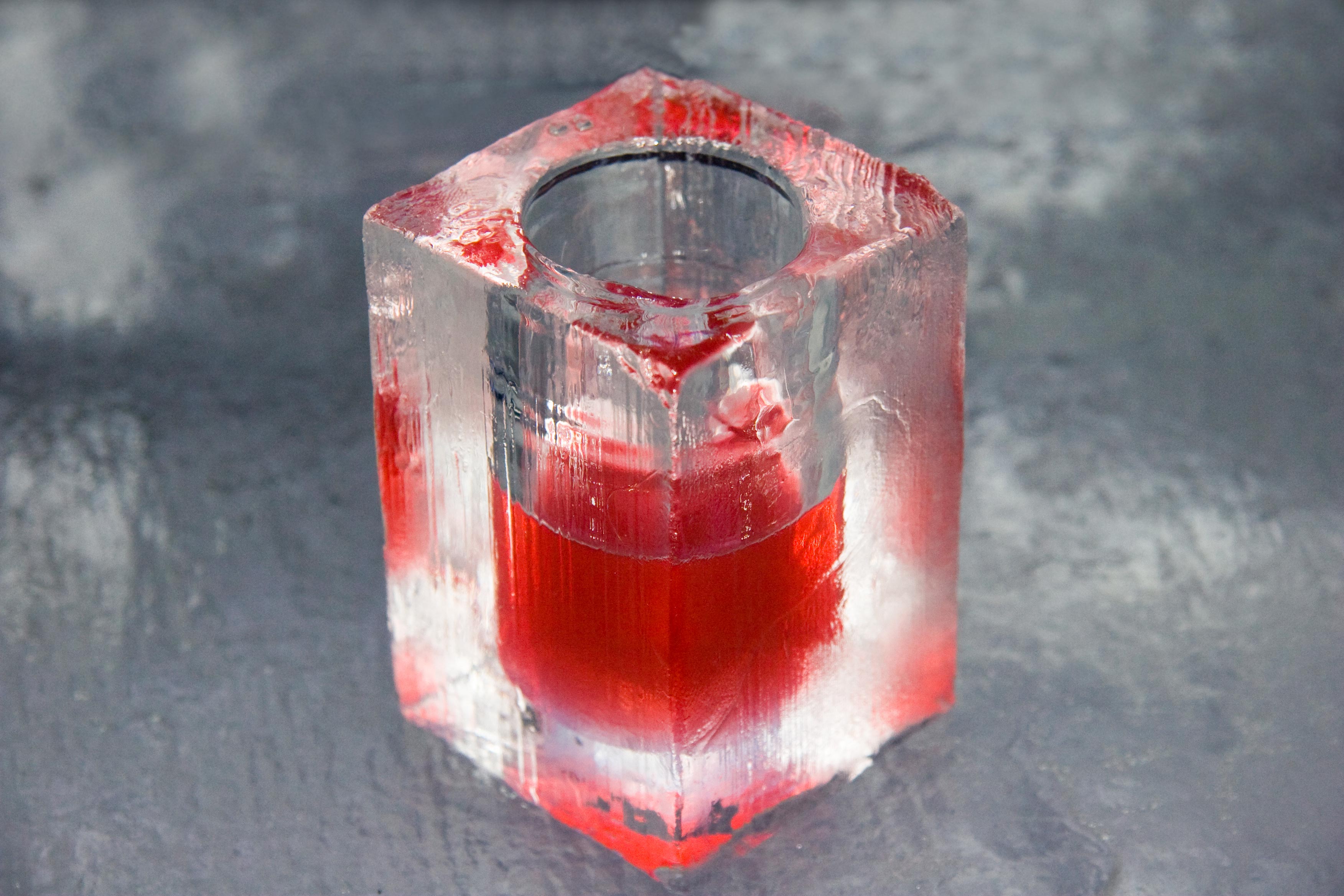 Red drink in an ice glass at an ice bar.