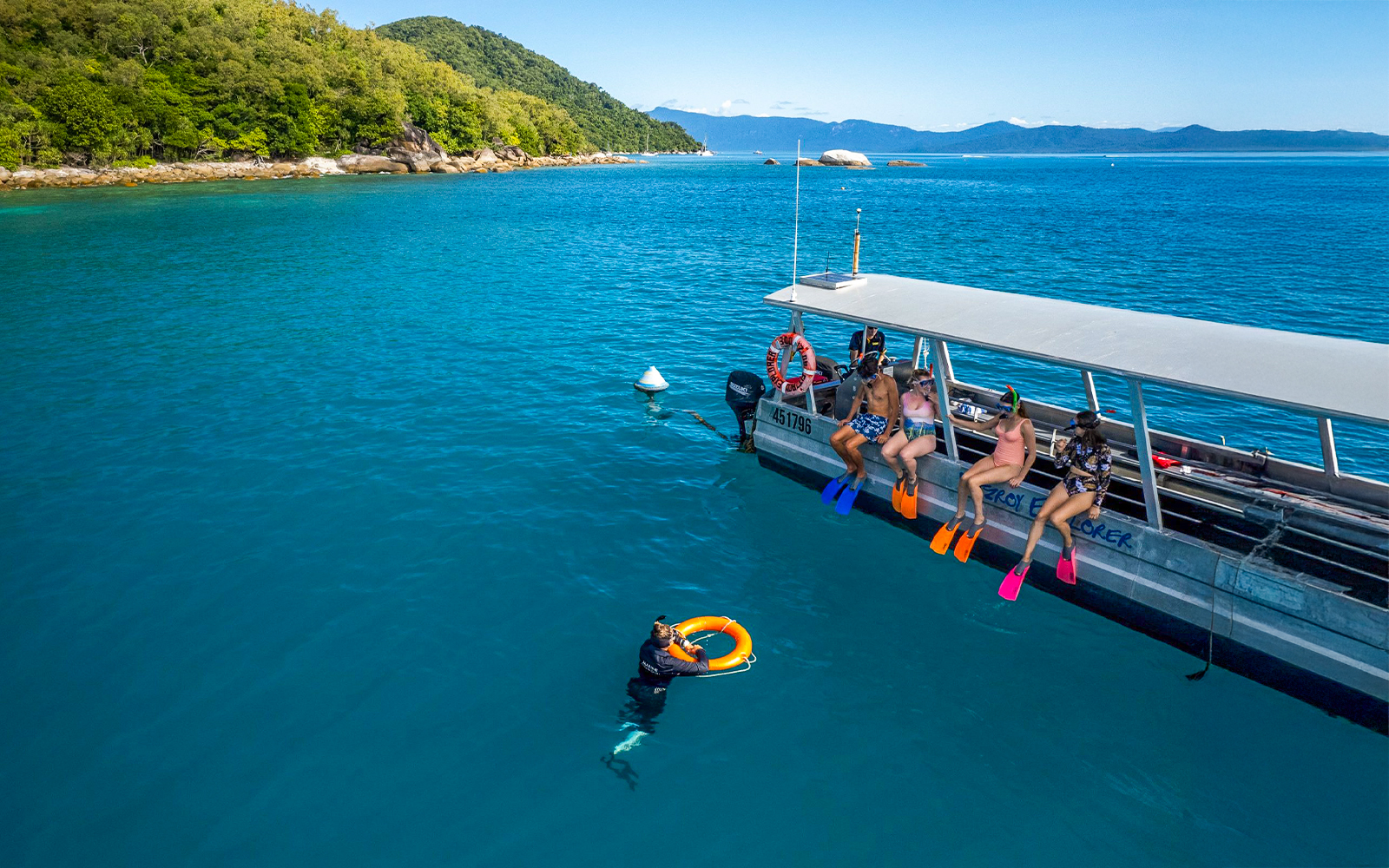 Tourists snorkeling from a boat at Fitzroy Island, Australia.