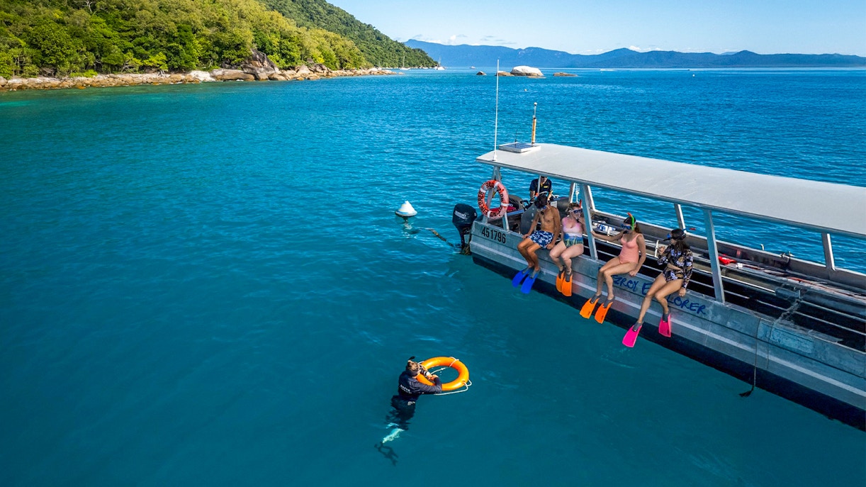 Tourists snorkeling from a boat at Fitzroy Island, Australia.