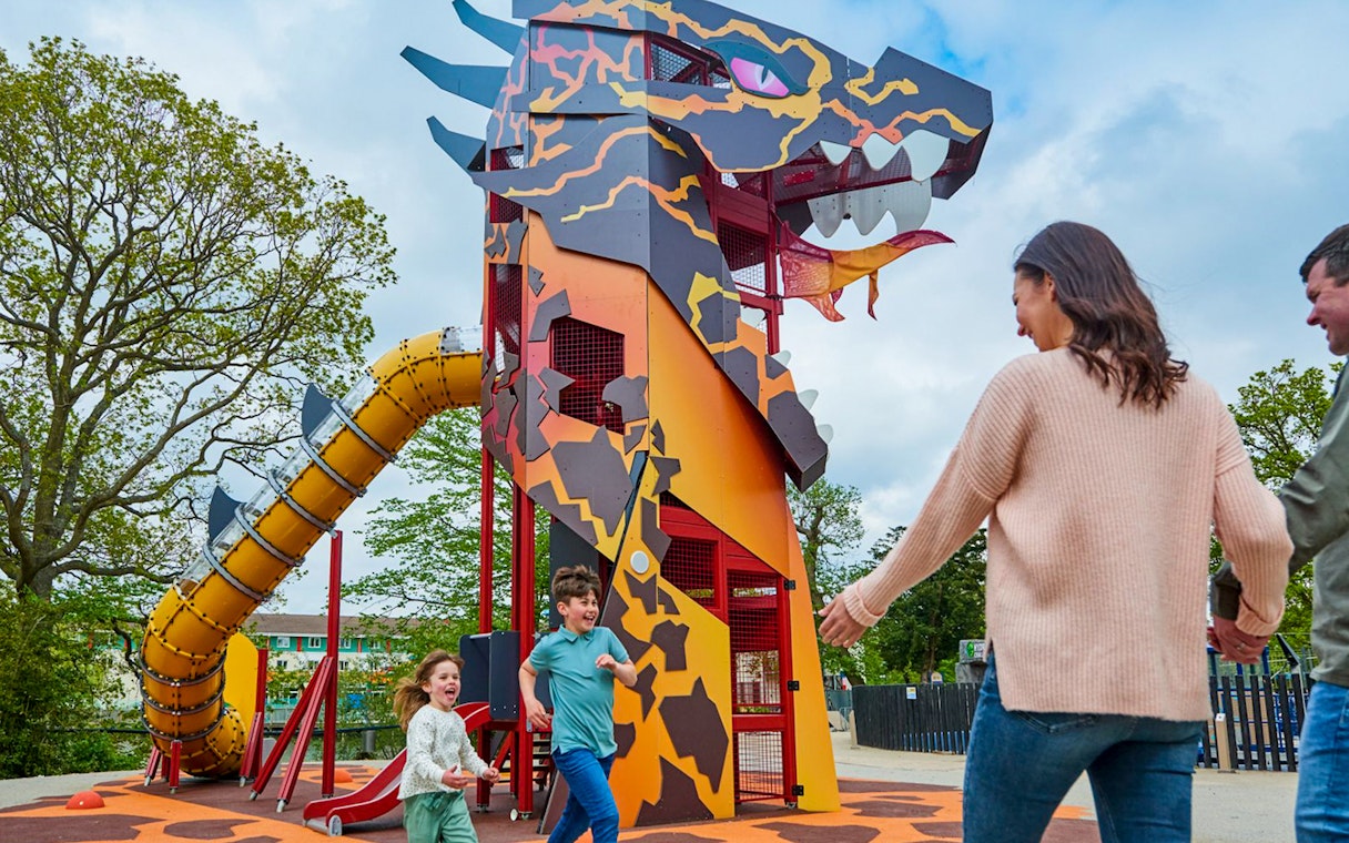 Children playing near dragon-themed slide at LEGOLAND® Windsor Resort.