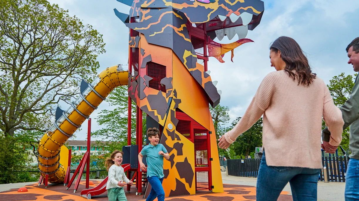 Children playing near dragon-themed slide at LEGOLAND® Windsor Resort.