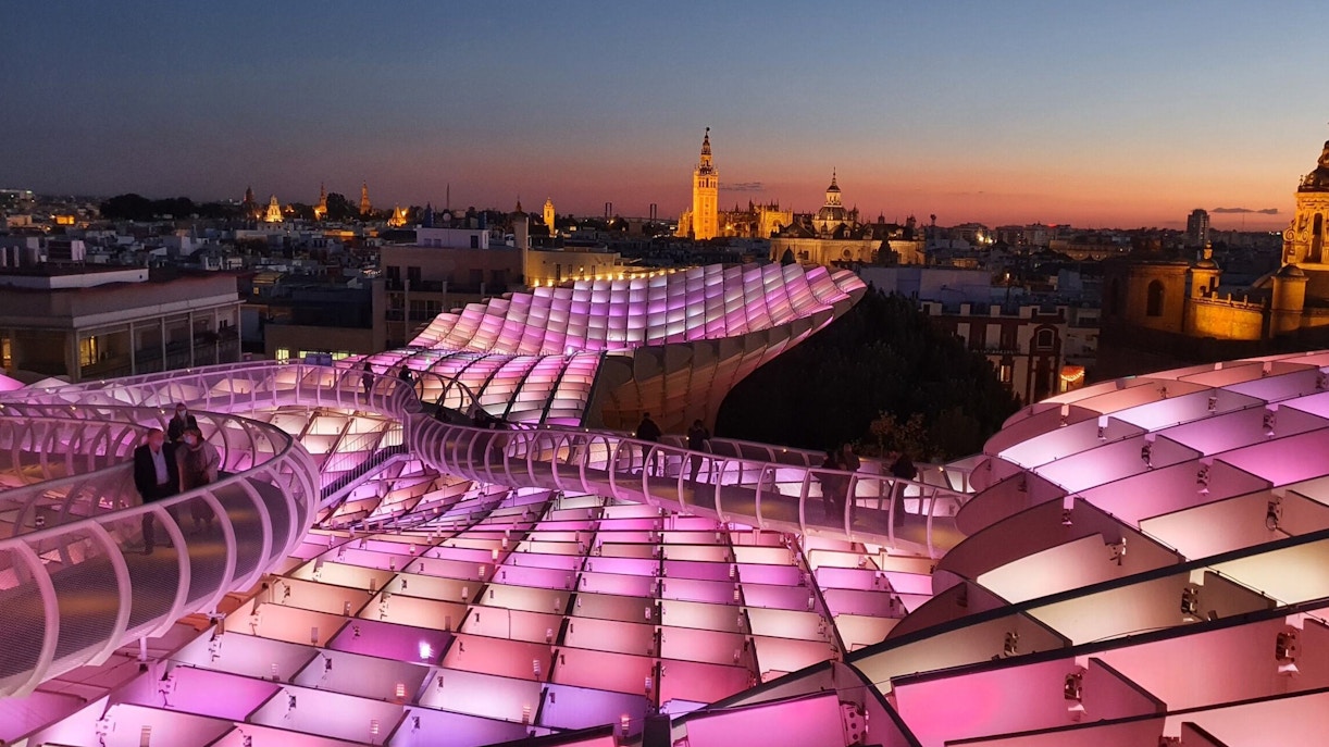 Visitors walking on illuminated Setas de Sevilla at night, Spain.