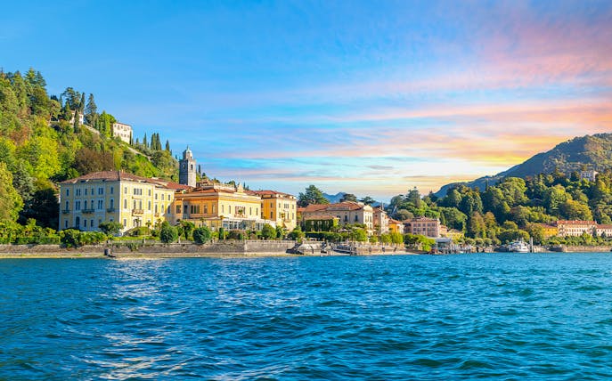 Lake Como shoreline with historic villas and lush hills during a public tour.