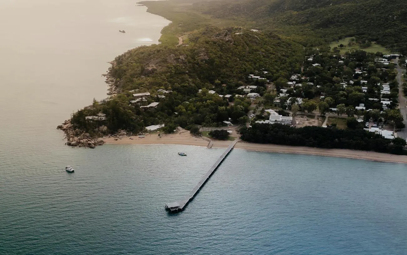 Aerial view of Magnetic Island coastline with boats near the pier, Townsville.