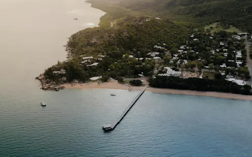 Aerial view of Magnetic Island coastline with boats near the pier, Townsville.