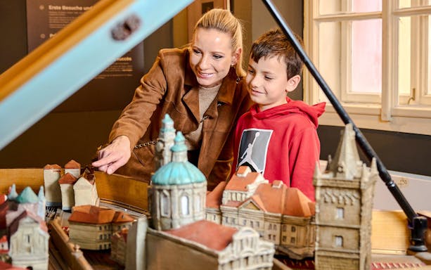 Guests examining a model of Prague landmarks at Mozart Interactive Museum.