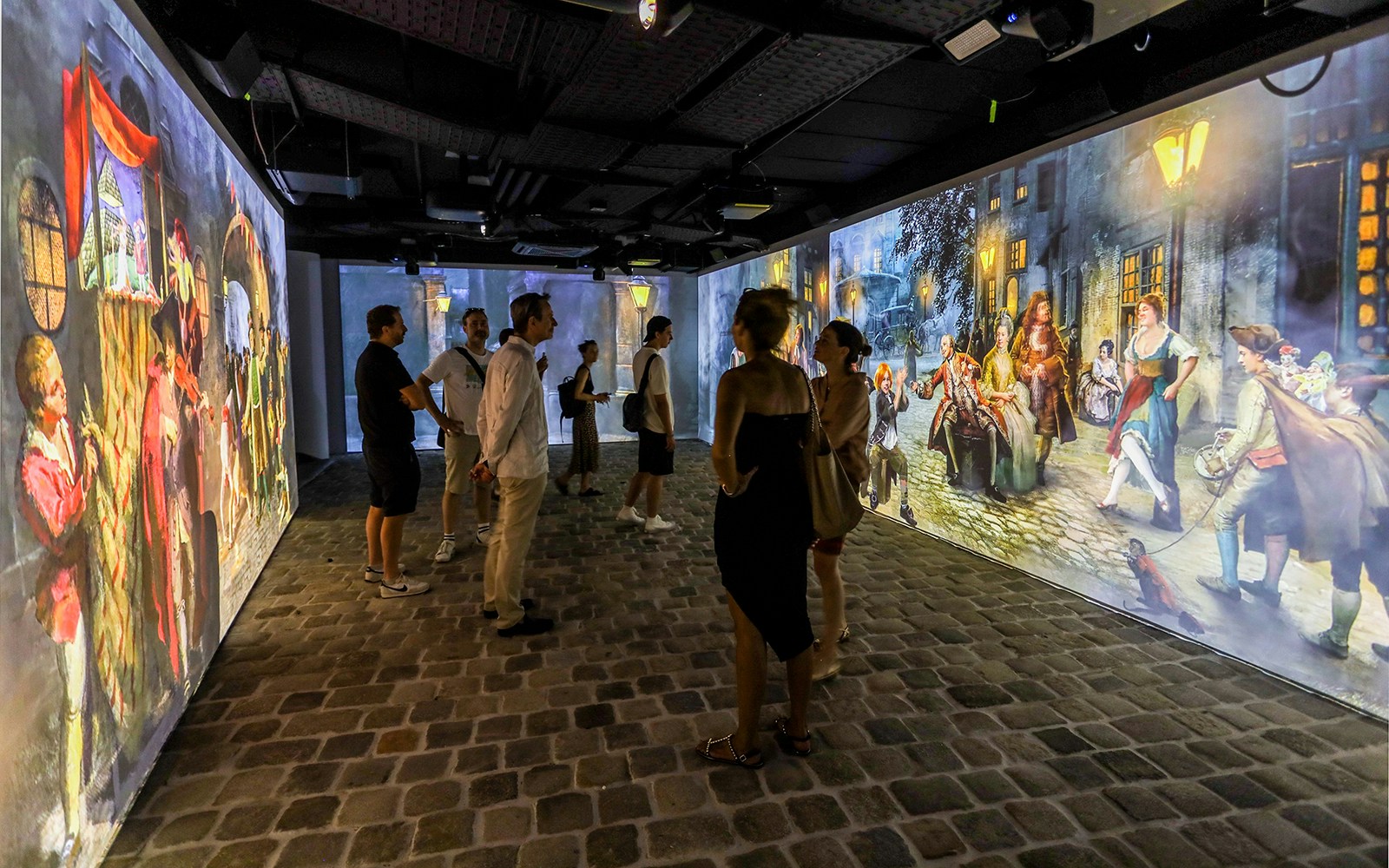 Visitors viewing immersive Mozart-themed projections at an exhibition.