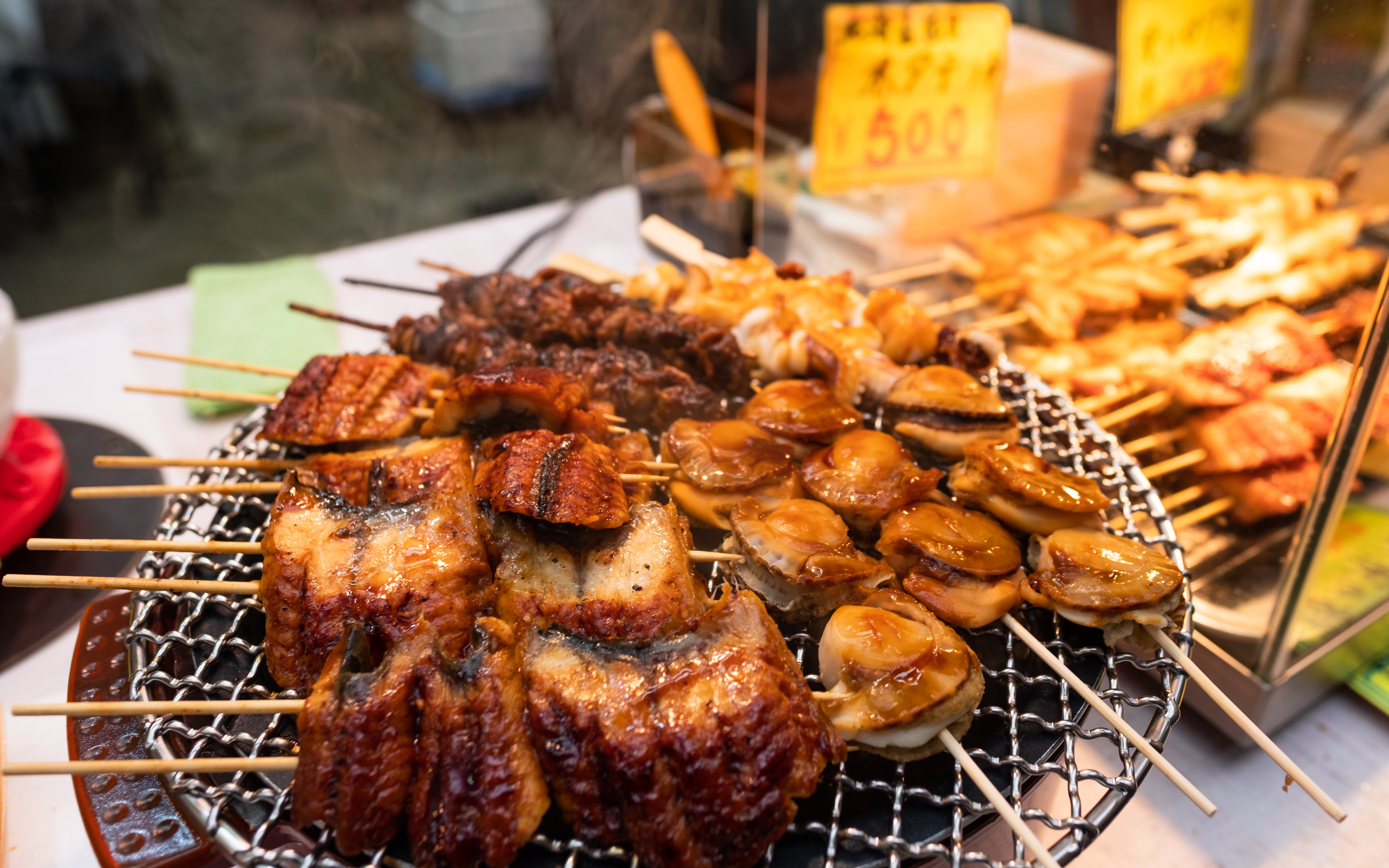 Grilled seafood skewers on a street food stall in Osaka, Japan.