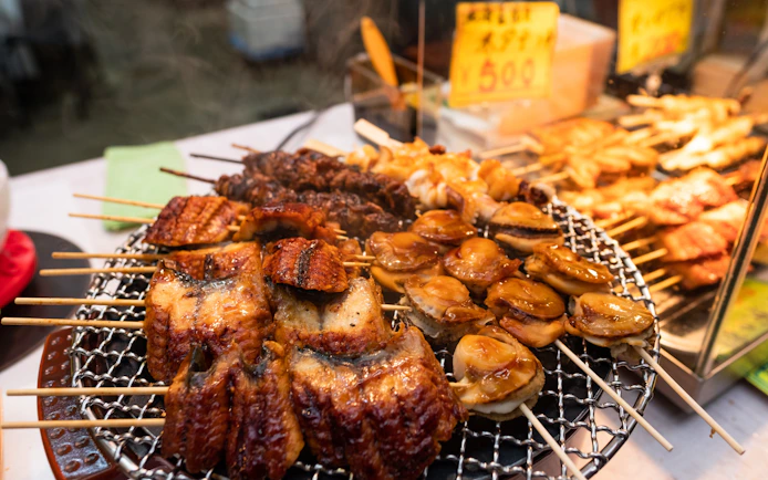 Grilled seafood skewers on a street food stall in Osaka, Japan.