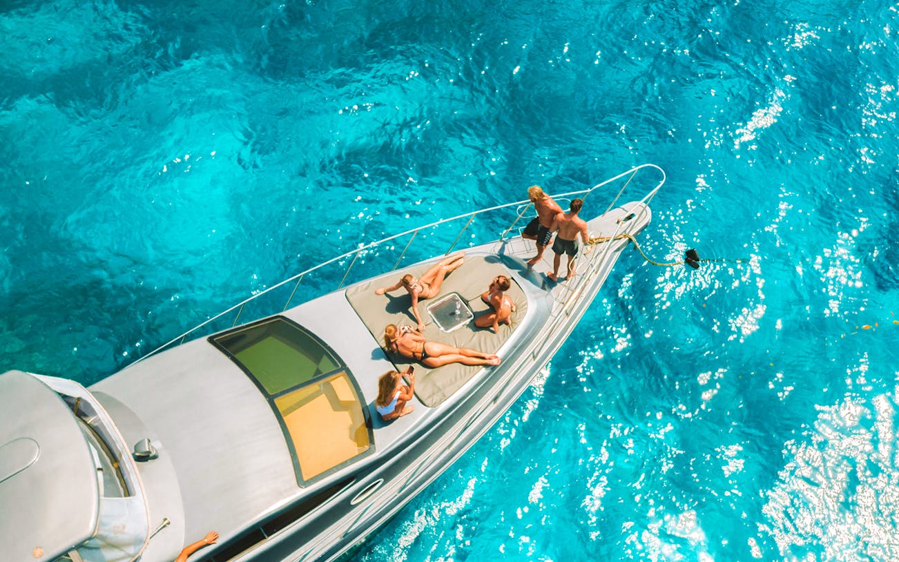 People relaxing on a speedboat in clear blue waters near Nusa Penida.