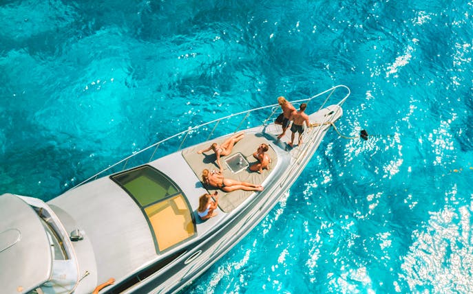 People relaxing on a speedboat in clear blue waters near Nusa Penida.
