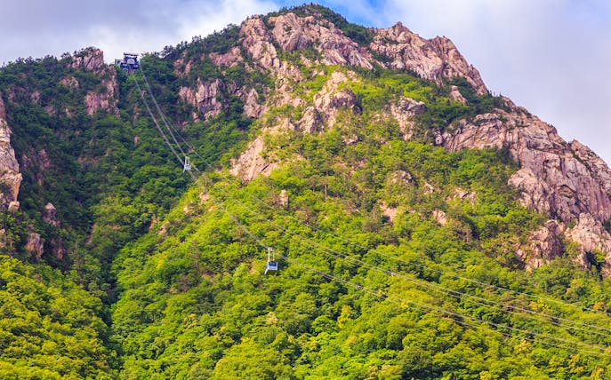 Cable car ascending Mount Seorak with lush greenery, South Korea.