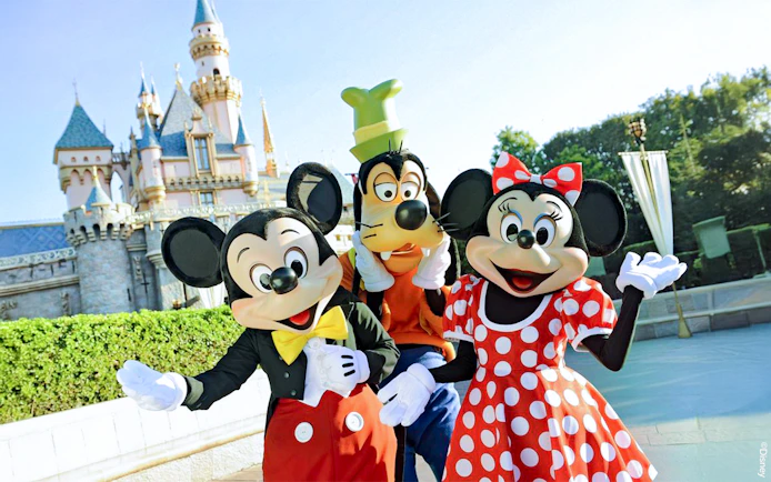 Mickey, Goofy, and Minnie in front of Disneyland Castle, California.