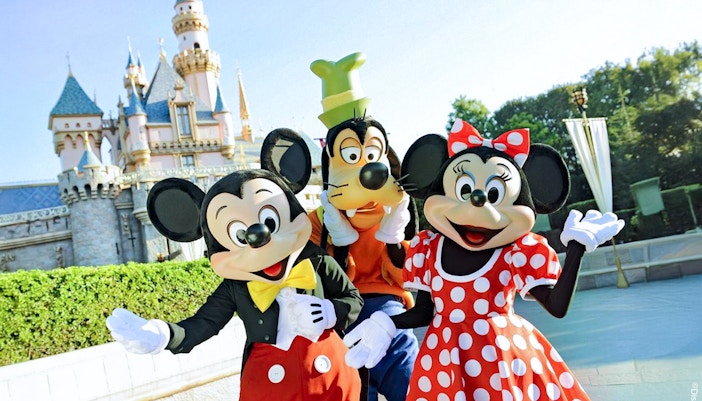 Mickey, Goofy, and Minnie in front of Disneyland Castle, California.